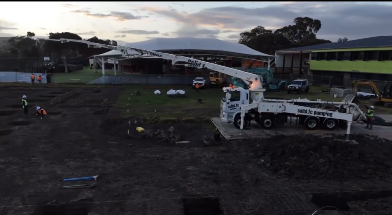 Solid FC boom pump extended over large jobsite